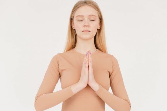 Woman practicing meditation with eyes closed, focusing on inner peace.